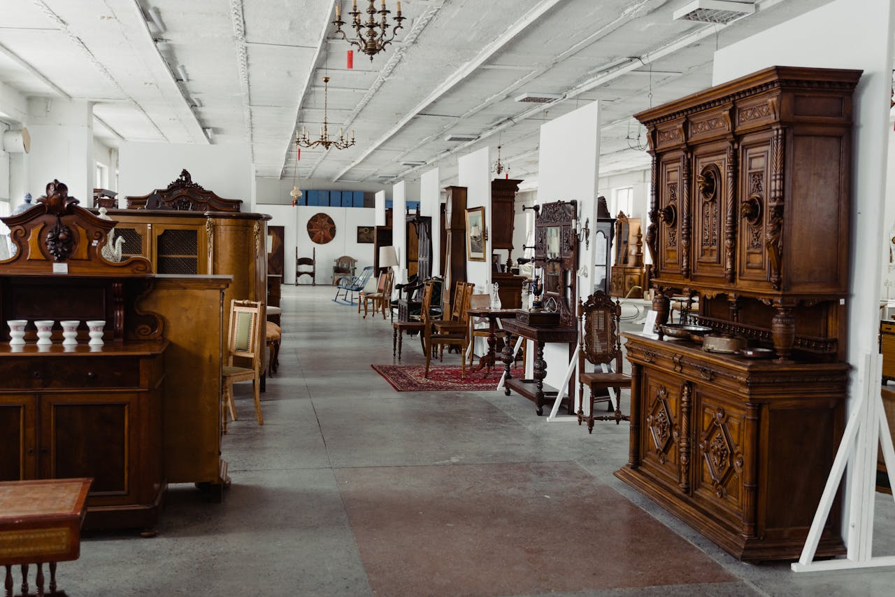 Home A spacious showroom filled with various antique wooden furniture pieces on display.